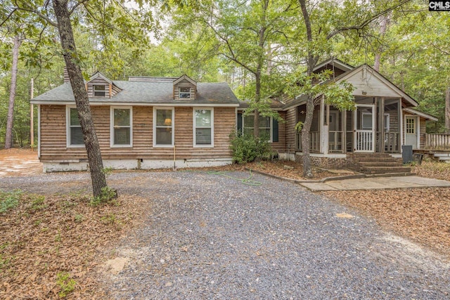 view of front of house featuring a sunroom, crawl space, and roof with shingles