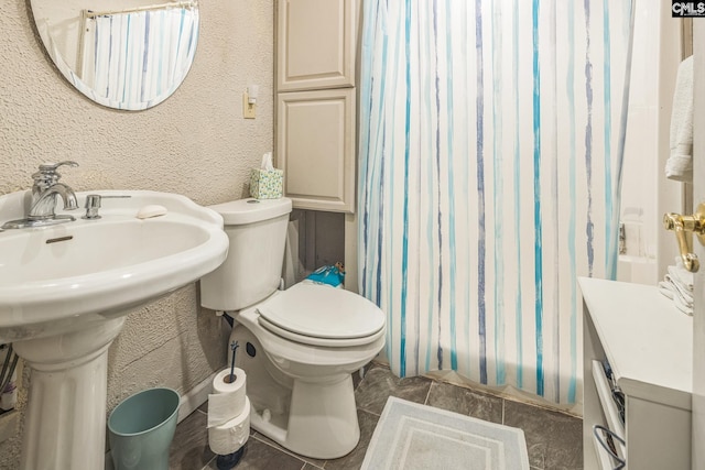 full bathroom featuring shower / bath combo with shower curtain, toilet, and a sink