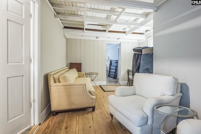 living area with wooden ceiling, baseboards, wooden walls, beamed ceiling, and hardwood / wood-style floors