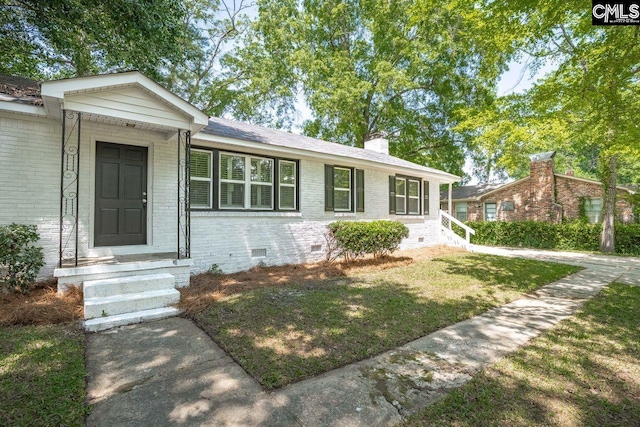 ranch-style house featuring a chimney, brick siding, entry steps, crawl space, and a front yard