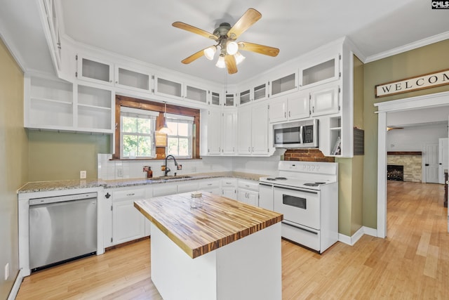 kitchen featuring open shelves, appliances with stainless steel finishes, butcher block countertops, and a sink