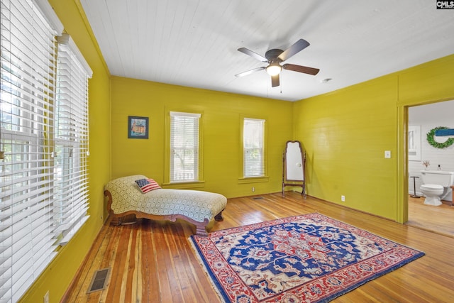 sitting room with a ceiling fan, visible vents, and hardwood / wood-style flooring