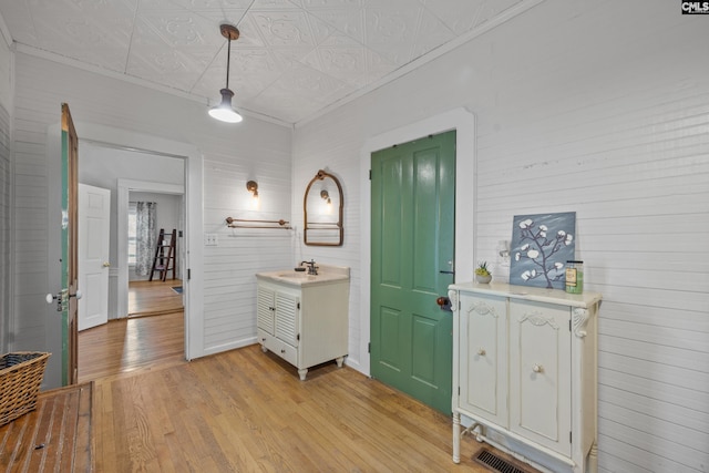 entrance foyer with light wood-style floors, ornamental molding, and an ornate ceiling