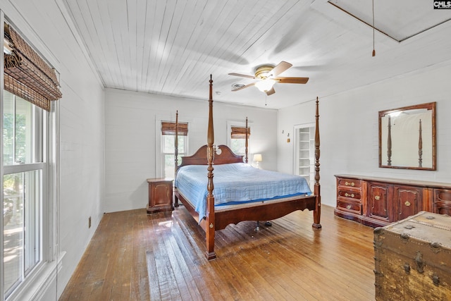 bedroom featuring ceiling fan, attic access, and hardwood / wood-style floors