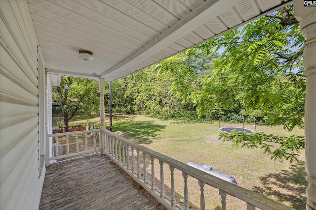 wooden terrace with a porch and a lawn
