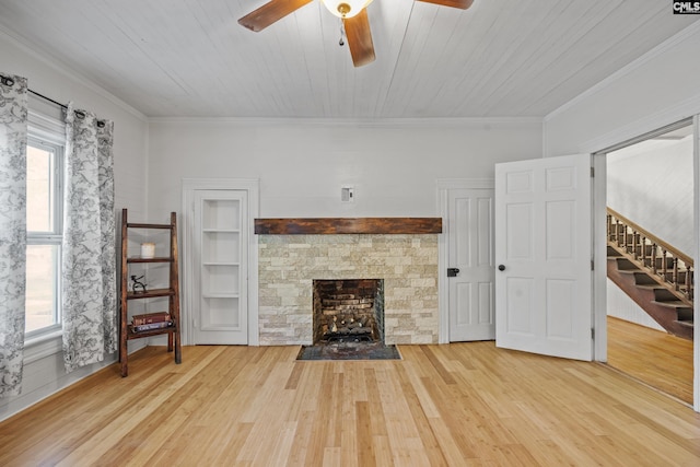 unfurnished living room with a ceiling fan, stairs, crown molding, and wood finished floors