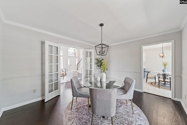 dining space featuring dark wood-style flooring, french doors, ornamental molding, and a notable chandelier