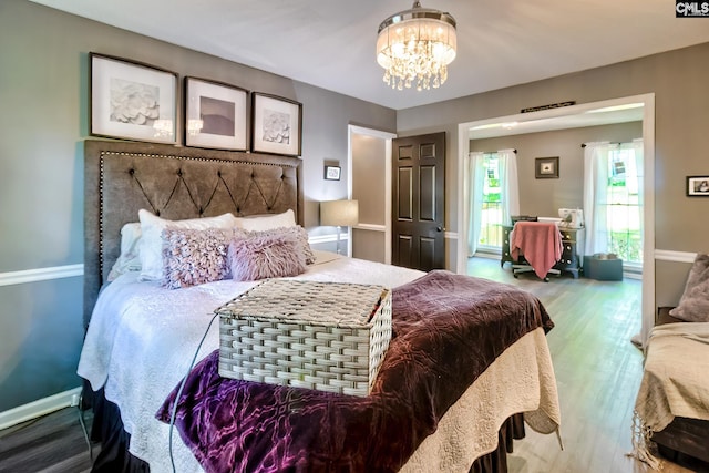 bedroom with an inviting chandelier and wood finished floors