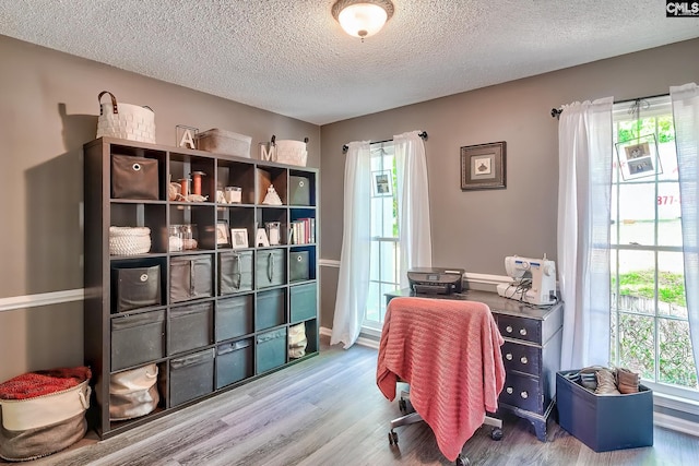 office area with baseboards, a textured ceiling, and wood finished floors