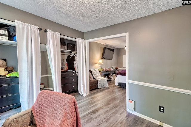 bedroom featuring a closet, a textured ceiling, and wood finished floors