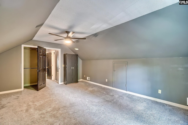 bonus room with visible vents, baseboards, ceiling fan, light colored carpet, and vaulted ceiling