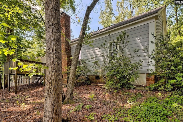 view of home's exterior featuring a chimney, a deck, and crawl space