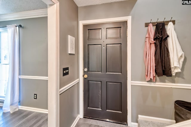 entryway featuring a textured ceiling and baseboards