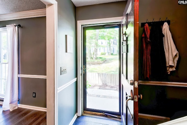 entryway with a textured ceiling, baseboards, and wood finished floors
