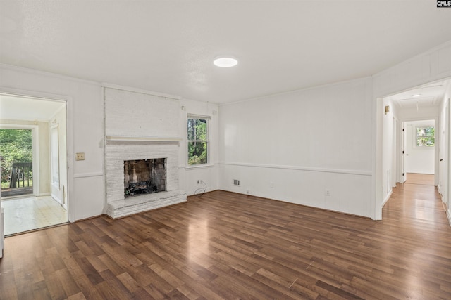 5227 Bush River Rd, Columbia, SC 29212 - unfurnished living room featuring wood finished floors, healthy amount of natural light, a fireplace, and attic access