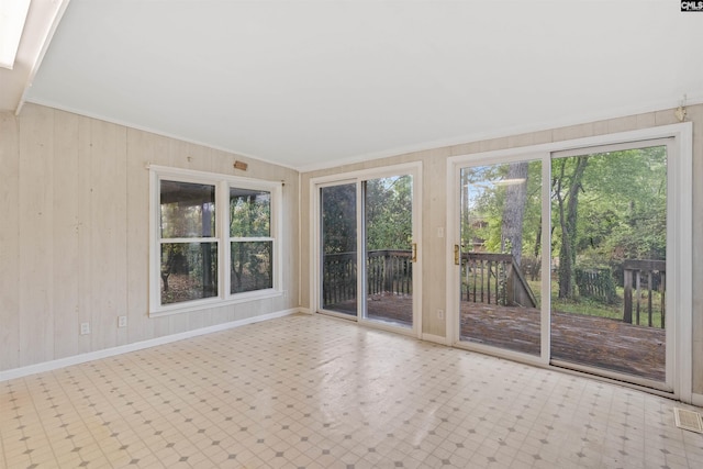 5227 Bush River Rd, Columbia, SC 29212 - unfurnished sunroom featuring plenty of natural light, tile patterned floors, wood walls, crown molding, and baseboards