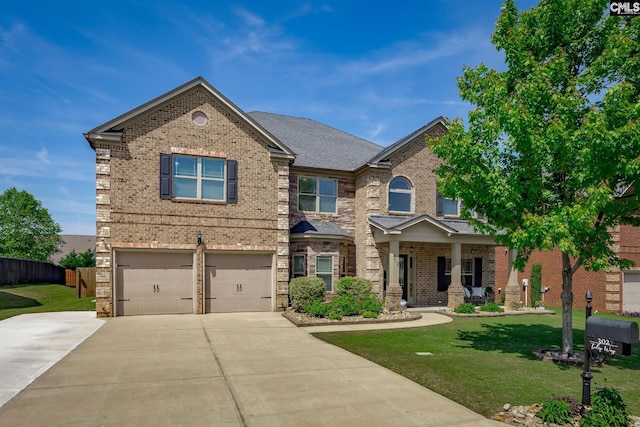 craftsman house with concrete driveway, brick siding, fence, and a front yard