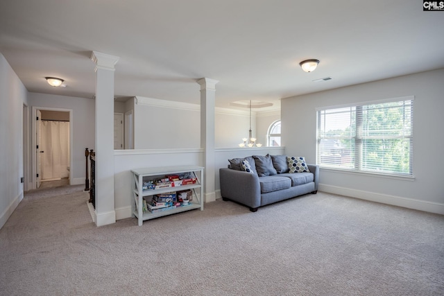 carpeted living area with visible vents, baseboards, ornate columns, and a notable chandelier