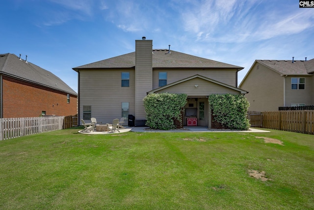 back of house featuring a fire pit, a yard, a patio, a fenced backyard, and a chimney
