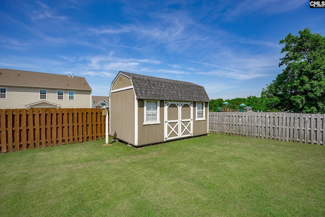 view of yard featuring a storage unit, an outdoor structure, and a fenced backyard