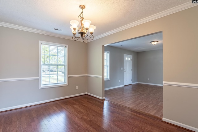 empty room featuring an inviting chandelier, baseboards, visible vents, and wood finished floors