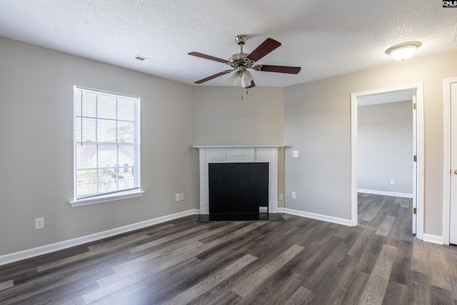 unfurnished living room with a ceiling fan, visible vents, a textured ceiling, and dark wood-type flooring