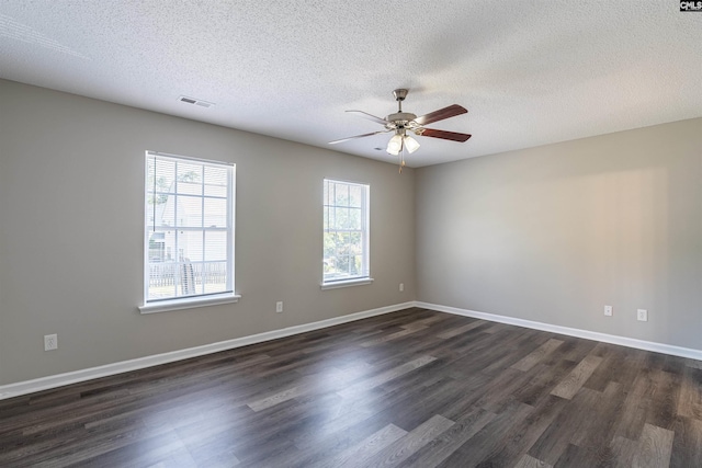 spare room with dark wood-style flooring, a textured ceiling, a ceiling fan, and visible vents