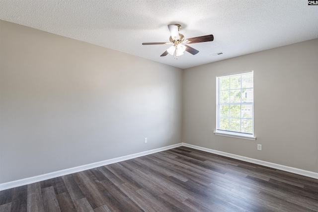 spare room with baseboards, visible vents, ceiling fan, and dark wood-style floors