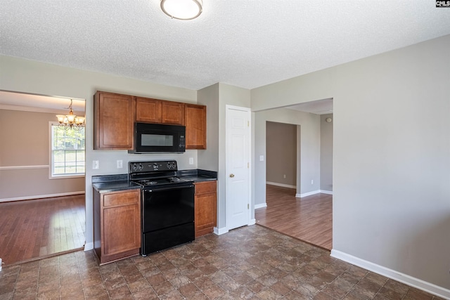 kitchen featuring baseboards, black appliances, dark countertops, and brown cabinets