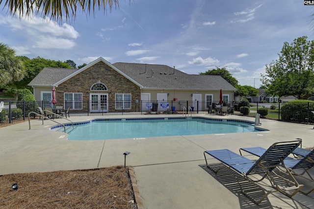 pool featuring fence and a patio area