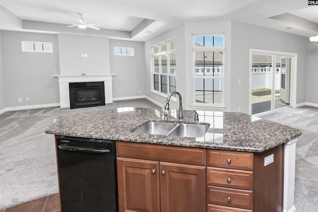 kitchen with a sink, carpet flooring, open floor plan, and a wealth of natural light