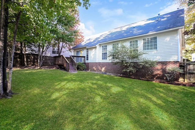 exterior space with brick siding, fence, and a lawn