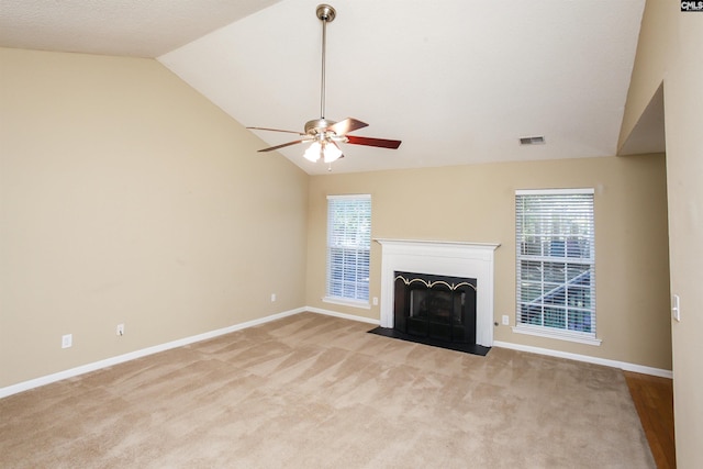 unfurnished living room featuring lofted ceiling, ceiling fan, a fireplace with flush hearth, and visible vents