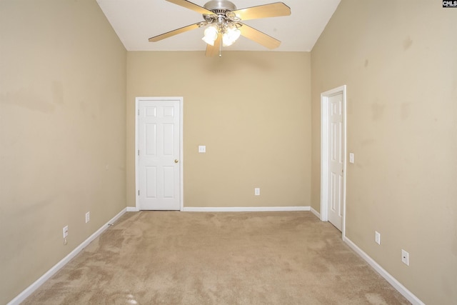 empty room featuring light colored carpet, baseboards, and a ceiling fan