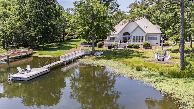 dock area with a deck with water view, a gazebo, and a lawn
