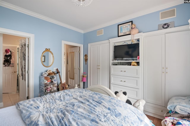 bedroom featuring ornamental molding and visible vents