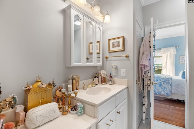 ensuite bathroom with crown molding, ensuite bathroom, tile patterned flooring, and vanity