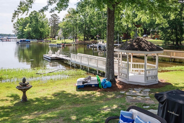 view of dock with a water view, a gazebo, and a lawn