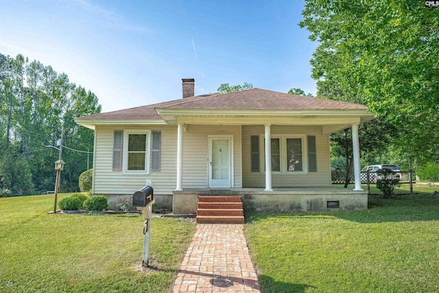 bungalow-style home with a chimney, a porch, and a front lawn