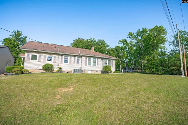 back of property featuring a yard, cooling unit, a chimney, and crawl space