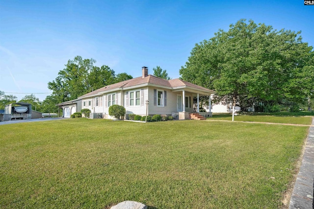 view of front of home featuring a chimney, driveway, a front lawn, and an attached garage