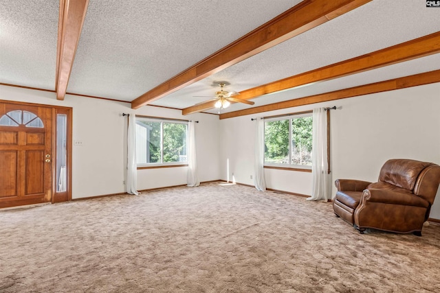 unfurnished living room with a wealth of natural light, carpet flooring, beam ceiling, and a textured ceiling