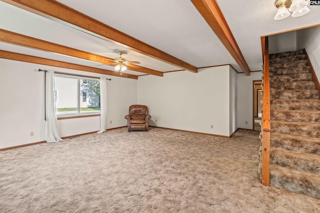 interior space featuring baseboards, ceiling fan, beamed ceiling, stairway, and carpet floors