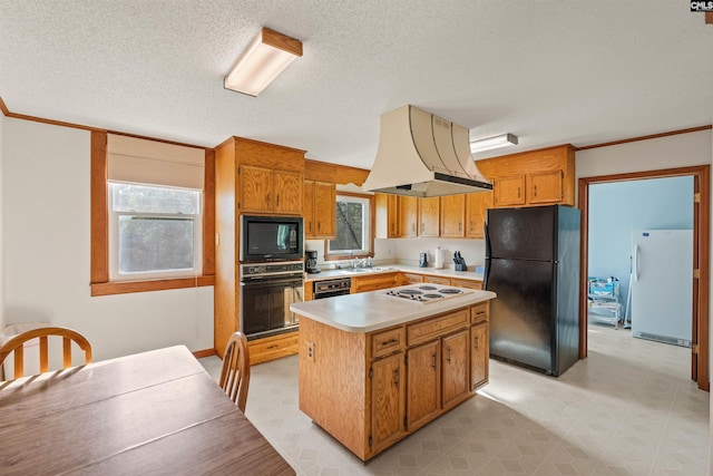 kitchen with a textured ceiling, black appliances, light countertops, a kitchen island, and custom exhaust hood