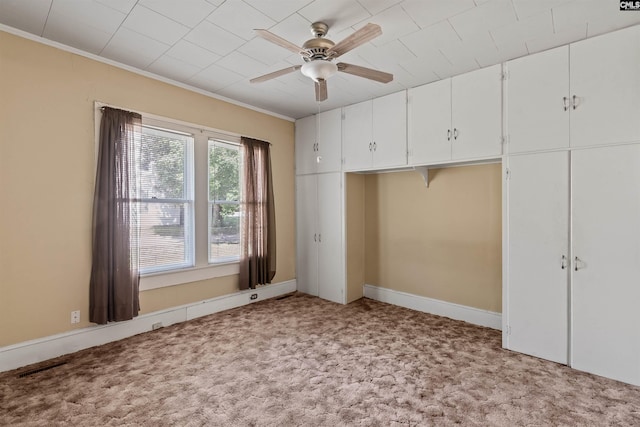 unfurnished bedroom with ceiling fan, ornamental molding, visible vents, and carpet floors