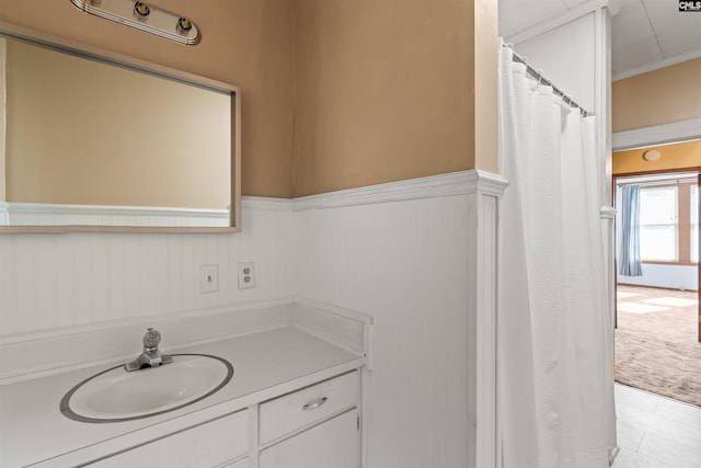 full bathroom with vanity and wainscoting