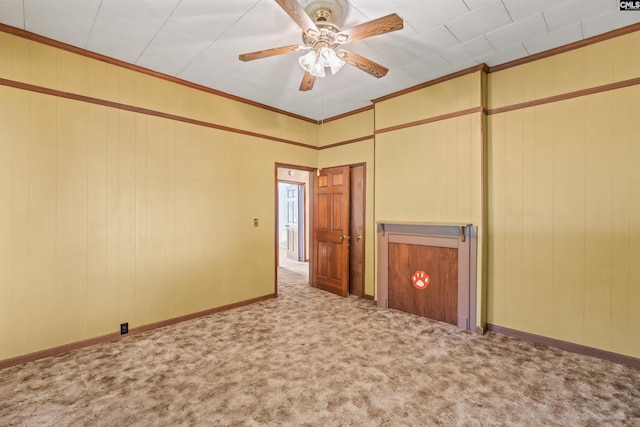 carpeted empty room featuring crown molding and ceiling fan