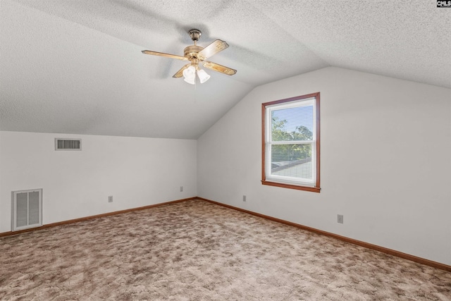 additional living space with lofted ceiling, ceiling fan, carpet flooring, and visible vents