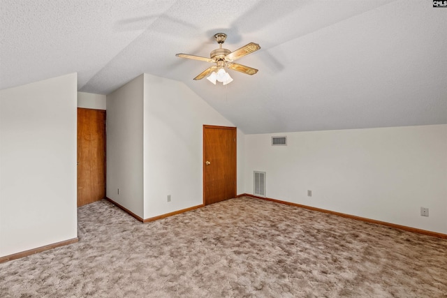 bonus room featuring carpet flooring, visible vents, and vaulted ceiling