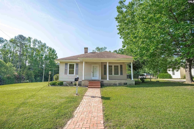 bungalow-style house featuring a chimney, a porch, and a front lawn